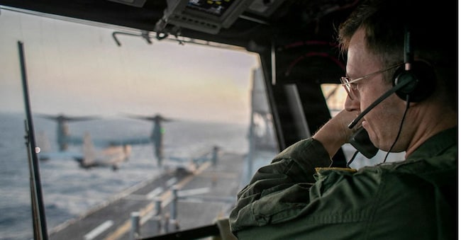 Un ufficiale, a bordo della USS Tripoli, supervisiona operazioni di volo     REUTERS
