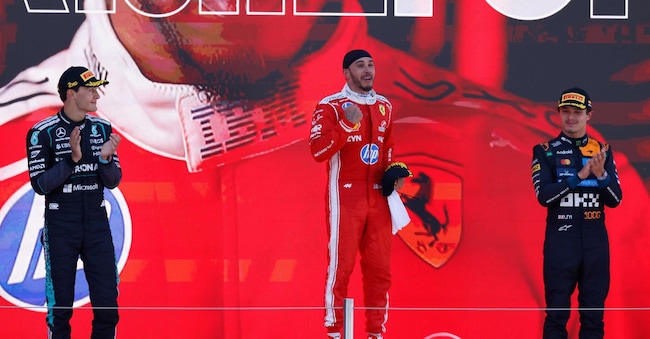 Il pilota della Ferrari Lewis Hamilton, al centro, festeggia sul podio accanto al connazionale George Russell della Mercedes, a sinistra, secondo classificato, e al pilota della McLaren Lando Norris durante il Gran Premio di Spagna di Formula 1 sul circuito del Camp de Catalunya a Montmeló, vicino a Barcellona, domenica 14 giugno 2026. (AP Photo/Joan Monfort)