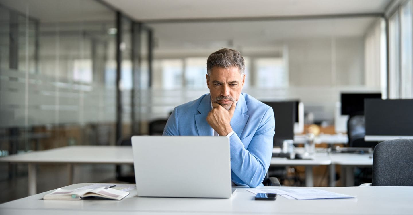 Busy serious middle aged professional business man financial investor, 50 year old senior businessman executive wearing suit using laptop computer working on investment project sitting at office desk. insta_photos - stock.adobe.com