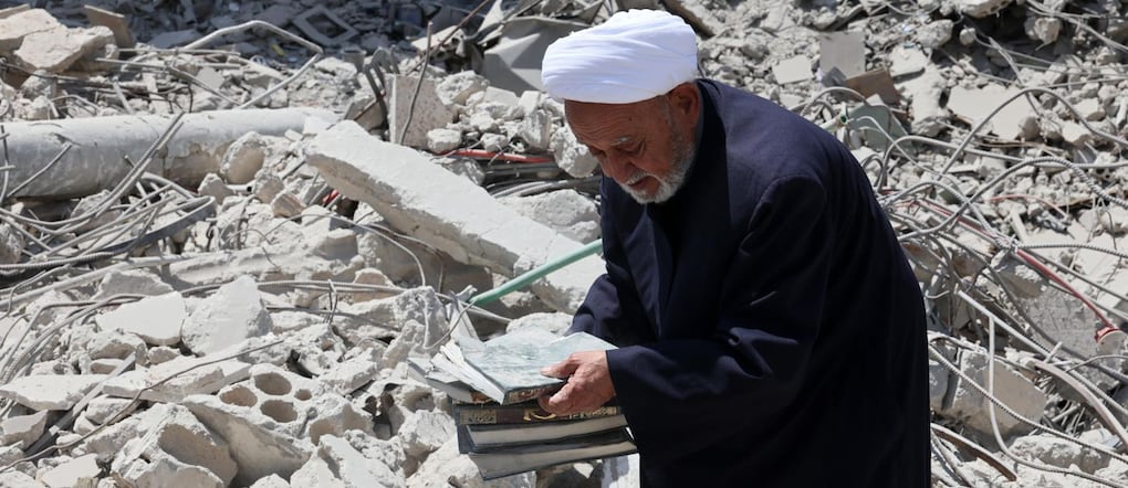 Una persona, tornata al suo villaggio, trasporta libri tra le macerie di un edificio distrutto in seguito a un attacco israeliano nel villaggio di Maaroub, nel Libano meridionale. EPA/WAEL HAMZEH. EPA/WAEL HAMZEH EPA