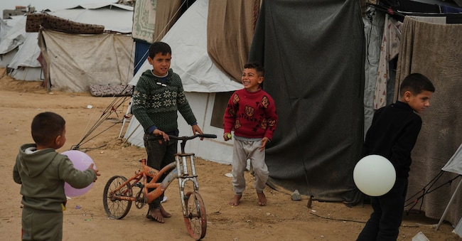 Bambini palestinesi giocano in un campo profughi a Khan Younis, nella Striscia di Gaza meridionale (AP Photo/Jehad Alshrafi)  APN