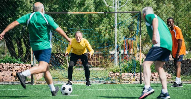 Un gruppo di anziani che giocano insieme a calcio (Adobe Stock)