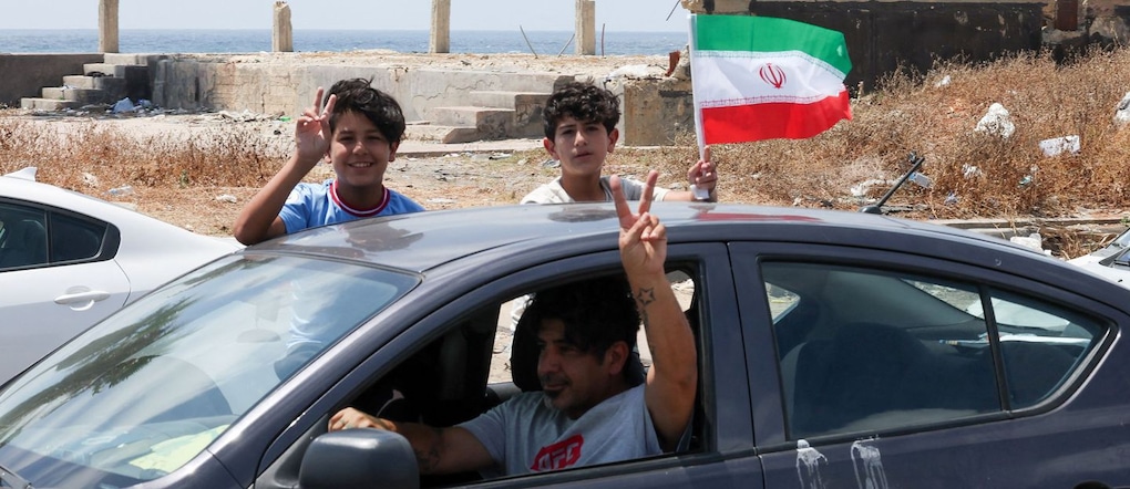 A boy waves an Iranian flag from a car as displaced people make their way back to their homes in southern Lebanon following an interim deal between the U.S. and Iran, in Sidon, Lebanon, June 24, 2026. REUTERS/Aziz Taher REUTERS