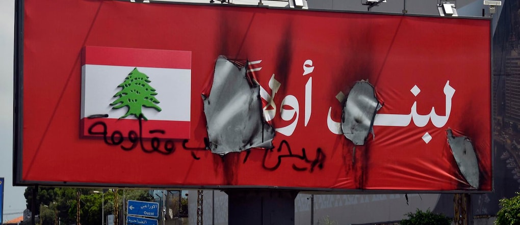 Un cartellone pubblicitario bruciato con la scritta “Prima il Libano” è visibile un giorno dopo essere stato installato lungo l’autostrada dell’aeroporto a Beirut, in Libano, il 28 giugno 2026.  EPA/WAEL HAMZEH EPA