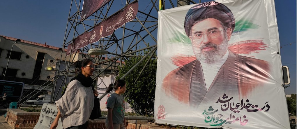 Lunedì 29 giugno 2026, nel centro di Teheran, in Iran, alcuni passanti camminano davanti a striscioni che raffigurano il leader supremo iraniano, l’ayatollah Mojtaba Khamenei. (AP Photo/Vahid Salemi)      Associated Press/ LaPresse Solo Italia e Spagna APN