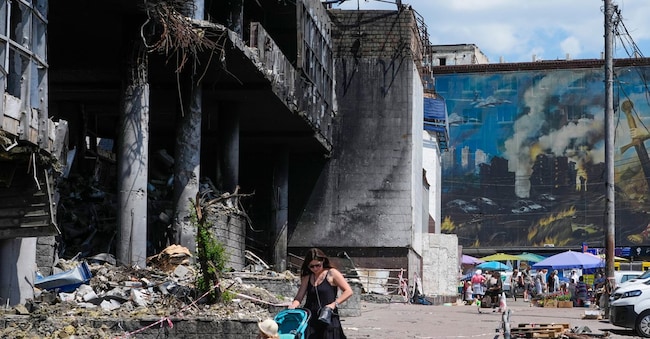 Una madre spinge un passeggino davanti a un edificio danneggiato, ricoperto da murales di street art, e accanto a un grande mercato cittadino recentemente distrutto da un attacco missilistico russo, a Kyiv, in Ucraina, lunedì 22 giugno 2026.(AP Photo/Efrem Lukatsky)





Associate Press/ LaPresse
Only Italy and Spain APN