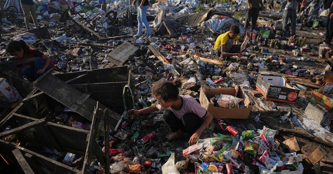 I palestinesi raccolgono cibo tra le macerie delle loro tende dopo un attacco aereo israeliano a Khan Younis, nella Striscia di Gaza, martedì 30 giugno 2026. (Foto AP/Abdel Kareem Hana) APN
