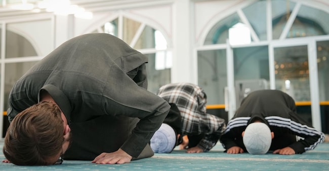 3DM2EKY Muslim Sheikh leading young boys in sujud prostration during congregational prayer. Group of Muslims performing Sajda at a mosque. Young scholar and k Alamy Stock Photo