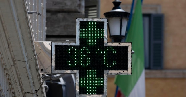 Turisti si proteggono dal caldo bevendo e utilizzando degli ombrelli al centro storico della Capitale. Roma, 24 giugno 2026. ANSA/MASSIMO PERCOSSI ANSA