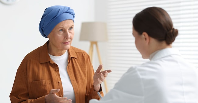 Una donna affetta da cancro in visita dall'oncologo in ambulatorio (Adobe Stock)