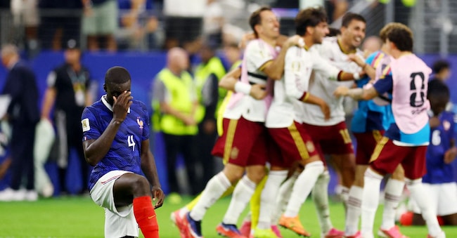 Calcio - Coppa del Mondo FIFA 2026 - Semifinale - Francia contro Spagna - Dallas Stadium, Arlington, Texas, Stati Uniti - 14 luglio 2026 Il francese Dayot Upamecano appare abbattuto dopo la partita, in cui la Francia è stata eliminata, mentre i giocatori spagnoli festeggiano la qualificazione alla finale dei Mondiali.  REUTERS/Albert Gea