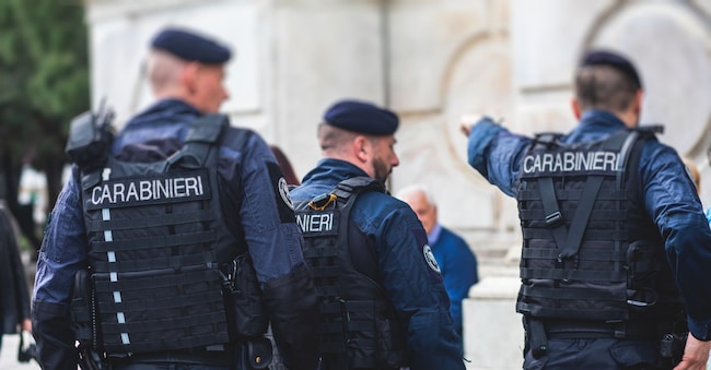 Italian Carabinieri, national gendarmerie of Italy squad,  of Italy patrol formation back view with "Carabiners" logo emblem on uniform maintain public order in the streets of Florence, Italy, Italia tsuguliev - stock.adobe.com