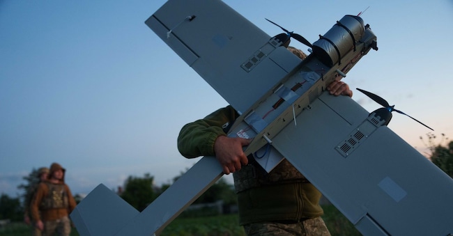 Un militare ucraino della brigata K-2 trasporta un drone a medio raggio APN