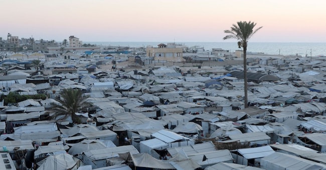 I palestinesi sfollati trovano rifugio in un campo tendato, in un contesto caratterizzato dalla carenza di accendini e gas da cucina che ha costretto molte famiglie a ricorrere al fuoco di legna per cucinare, a Khan Younis, nella parte meridionale della Striscia di Gaza, il 21 luglio 2026. REUTERS/Ramadan Abed REUTERS