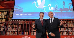Da sinistra: il presidente della Fondazione La Biennale di Venezia Pietrangelo Buttafuoco e Il direttore del Settore Cinema della Fondazione La Biennale Alberto Barbera posano davanti il manifesto della 83esima Mostra Internazionale di Arte Cinematografica, poco prima della conferenza stampa di presentazione del programma della rassegna cinematografica, nella sede della biblioteca della Biennale, Venezia, 23 luglio 2026.  ANSA/Andrea Merola
