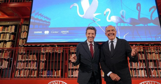 Da sinistra: il presidente della Fondazione La Biennale di Venezia Pietrangelo Buttafuoco e Il direttore del Settore Cinema della Fondazione La Biennale Alberto Barbera posano davanti il manifesto della 83esima Mostra Internazionale di Arte Cinematografica, poco prima della conferenza stampa di presentazione del programma della rassegna cinematografica, nella sede della biblioteca della Biennale, Venezia, 23 luglio 2026.  ANSA/Andrea Merola