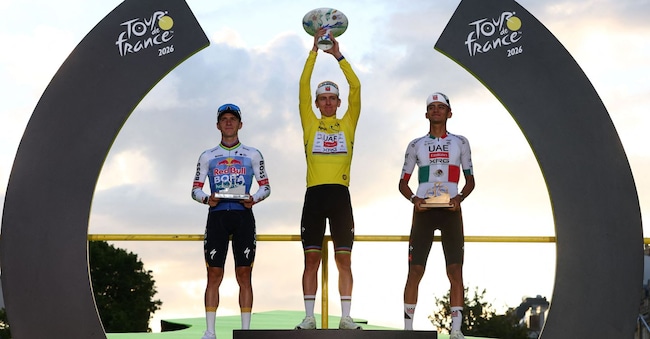 Ciclismo - Tour de France - 21ª tappa - Parigi, Francia - 26 luglio 2026 Tadej Pogacar dell'UAE Team Emirates XRG festeggia sul podio indossando la maglia gialla dopo aver vinto il Tour de France, affiancato da Isaac Del Toro dell'UAE Team Emirates XRG, che indossa la maglia bianca, e da Red Bull - Remco Evenepoel della BORA - hansgrohe REUTERS/Gonzalo Fuentes REUTERS