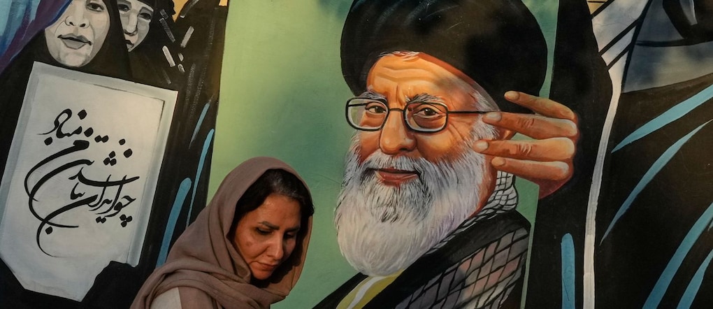 Una donna passa davanti a un murale raffigurante il ritratto del defunto leader supremo iraniano, l’ayatollah Ali Khamenei, rimasto ucciso nell’attacco sferrato da Stati Uniti e Israele il 28 febbraio, nel centro di Teheran, in Iran, sabato 18 luglio 2026. (AP Photo/Vahid Salemi) APN