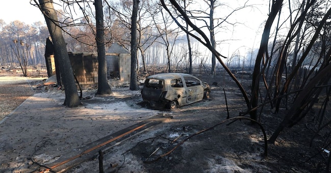 Un'auto bruciata giace in una zona colpita da un incendio boschivo a Le Porge, nella Gironda, in un contesto di siccità causato da un'ondata di caldo e da carenze idriche in gran parte della Francia, il 28 luglio 2026. REUTERS/Yves Herman REUTERS