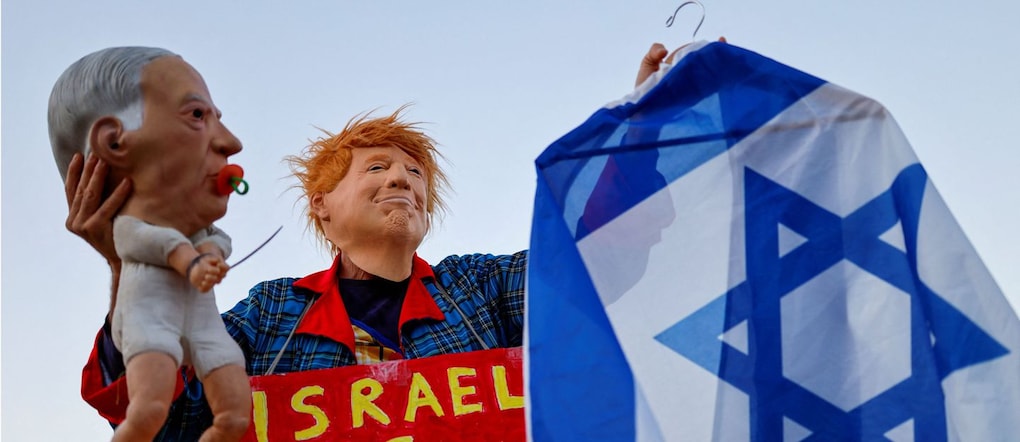 Un manifestante con indosso una maschera raffigurante il presidente degli Stati Uniti Donald Trump tiene in mano una bambola con il volto del primo ministro israeliano Benjamin Netanyahu durante le proteste contro le violenze commesse dai coloni israeliani ai danni dei palestinesi nella Cisgiordania occupata, a Tel Aviv, Israele, il 28 luglio 2026. REUTERS/Amir Cohen Reuters