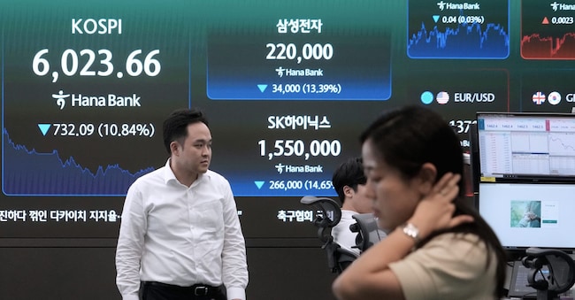 Currency traders pass by a screen showing the Korea Composite Stock Price Index (KOSPI), SK Hynix and Samsung Electronics Co. stock price at the foreign exchange dealing room of the Hana Bank headquarters in Seoul, South Korea, Tuesday, July 28, 2026. (AP Photo/Ahn Young-joon) APN