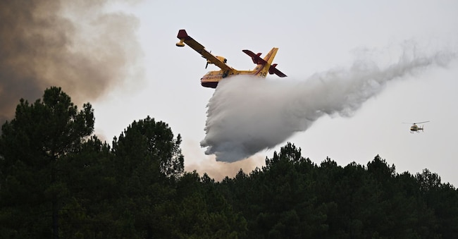 Un aereo scarica il proprio serbatoio d'acqua su un incendio nei pressi di Saint-Jean-d'Illac, durante gli incendi boschivi nel sud-ovest della Francia, martedì 28 luglio 2026. (AP Photo/Emma Da Silva)     Associated Press / LaPresse Solo Italia e Spagna APN