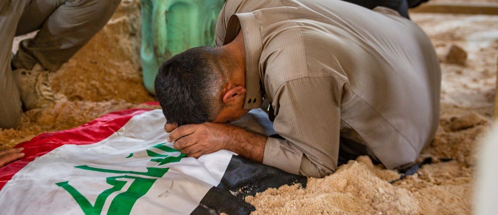 Un partecipante al funerale piange davanti a una tomba durante le esequie dei combattenti delle Forze di Mobilitazione Popolare (PMF) uccisi nei raid aerei contro le basi delle PMF a Najaf, in Iraq, giovedì 30 luglio 2026. (Foto AP/Anmar Khalil) APN