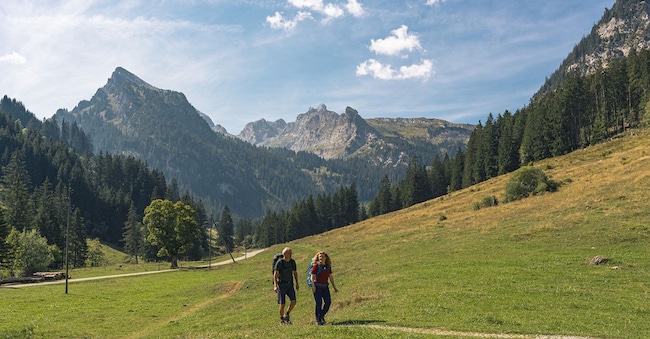 Una coppia durante un'escursione nella valle del Diemtigtal. Sullo sfondo si vedono le montagne.