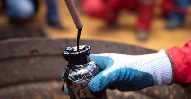 A worker collects crude oil sample at an oil well operated by Venezuela's state oil company PDVSA in Morichal July 28, 2011. PDVSA will invest $18 billion this year with $2 billion of that earmarked for new output from the OPEC nation's vast Orinoco heavy crude fields, officials said on Thursday. REUTERS/Carlos Garcia Rawlins (VENEZUELA - Tags: ENERGY POLITICS BUSINESS) REUTERS