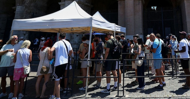FOTO D'ARCHIVIO: Turisti in fila sotto il sole davanti al Colosseo durante una giornata di caldo a Roma, Italia, il 20 giugno 2026. REUTERS/Guglielmo Mangiapane/Foto d'archivio Reuters