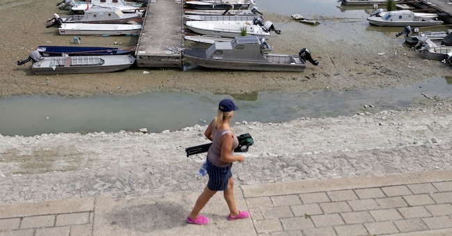Una donna cammina lungo il porto turistico, con il letto del fiume prosciugato all’imboccatura del Danubio, mentre il livello dell’acqua si abbassa a causa del protrarsi del caldo e della siccità, ad Apatin, in Serbia, il 26 luglio 2026. REUTERS/Djordje Kojadinovic REUTERS