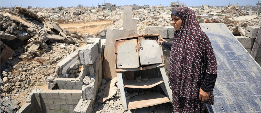 Soumah Dawla, una donna palestinese sfollata, osserva la scena dal tetto di una casa in cui ha trovato rifugio dopo essere stata costretta ad abbandonare la propria abitazione a causa dell’ulteriore avanzamento della “linea gialla” dell’esercito israeliano, a Gaza City, il 1° agosto 2026. REUTERS/Dawoud Abu Alkas REUTERS