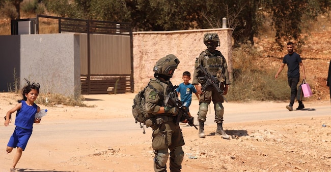Soldati israeliani sorvegliano alcuni palestinesi durante un raid nella città di Qusra, a sud di Nablus, in Cisgiordania, il 13 agosto 2026. L’esercito israeliano è entrato a Qusra dopo giorni di assedio da parte dei coloni alle abitazioni palestinesi e ha dichiarato l’area zona militare chiusa per smantellare l’avamposto illegale dei coloni, costringendo al contempo i residenti locali ad abbandonare le loro case per istituire postazioni militari. EPA/ALAA BADARNEHepaselect EPA
