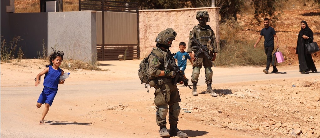 Soldati israeliani sorvegliano alcuni palestinesi durante un'incursione nella città di Qusra, a sud di Nablus, in Cisgiordania, il 13 agosto 2026. L’esercito israeliano è entrato a Qusra dopo giorni di assedio da parte dei coloni alle abitazioni palestinesi e ha dichiarato l’area zona militare chiusa per smantellare l’avamposto illegale dei coloni, costringendo al contempo i residenti locali ad abbandonare le loro case per istituire postazioni militari.  EPA/ALAA BADARNEH EPA