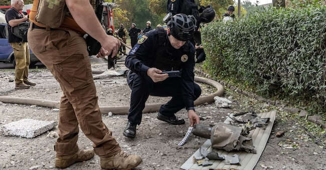 Un ufficiale di polizia controlla resti di un drone russo, dopo un attacco nella zona residenziale di Kharkiv in Ucraina  APN