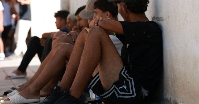 Alcuni minori in attesa di essere registrati, dopo aver varcato i confini spagnoli REUTERS