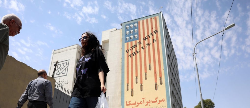 epa13175349 Alcuni cittadini iraniani passano davanti a un murale anti-statunitense a Teheran, in Iran, il 17 agosto 2026. EPA/ABEDIN TAHERKENAREH  EPA