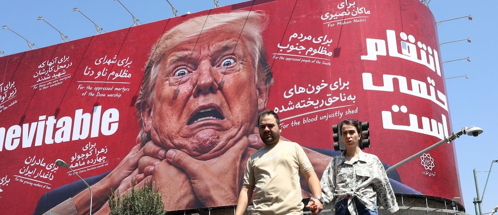 Alcuni iraniani passano accanto a un cartellone contro Trump a Teheran, in Iran.  EPA