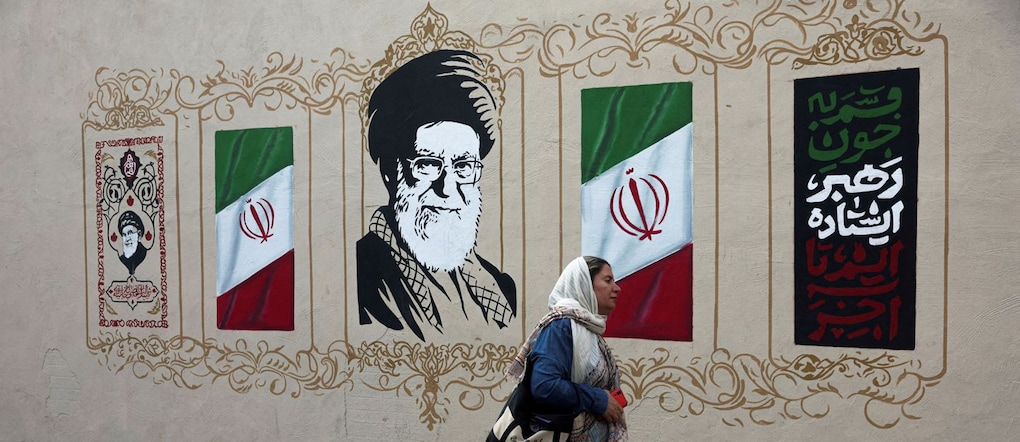 Una donna passa davanti a un murale raffigurante il defunto leader supremo iraniano, l’ayatollah Ali Khamenei, in una strada di Teheran, in Iran, il 13 agosto 2026. Majid Asgaripour/WANA (West Asia News Agency) via REUTERS /Foto d’archivio via REUTERS