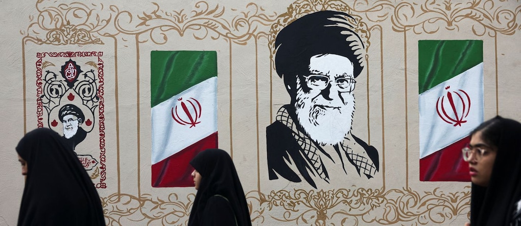 lcune persone passano davanti a un murale che raffigura il defunto Leader Supremo dell’Iran, l’Ayatollah Ali Khamenei, a Teheran REUTERS