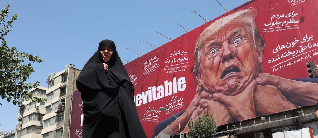 Una donna cammina accanto a un cartellone pubblicitario contro Trump a Teheran, in Iran, il 19 agosto 2026. Il presidente del Parlamento iraniano Mohammad Bagher Ghalibaf ha affermato che lo Stretto di Hormuz rimarrà chiuso fino a quando gli Stati Uniti non revocheranno il blocco e non porranno fine alle sanzioni.  EPA/ABEDIN TAHERKENAREH  EPA