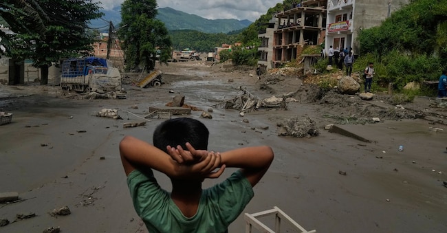 Un bambino osserva la devastazione causata da un'inondazione improvvisa lungo il fiume Trishuli, nel distretto di Nuwakot, in Nepal. Foto AP/Niranjan Shrestha
