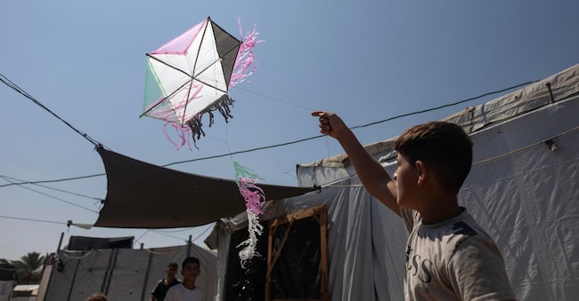  Un ragazzino palestinese fa volare un aquilone tra le tende del campo di al-Mawasi, vicino a Khan Younis, nella Striscia di Gaza meridionale, il 27 agosto 2026. Senza luoghi sicuri dove giocare, i bambini palestinesi sfollati costruiscono aquiloni con materiali di recupero per affrontare lo sfollamento e il caldo all’interno delle loro tende, e trovare un momento di sollievo. Tuttavia, i recenti avvertimenti dell’esercito israeliano contro il volo degli aquiloni hanno trasformato un innocuo gioco infantile in un’altra fonte di paura e ansia all’interno dei campi profughi.  EPA/HAITHAM IMAD EPA