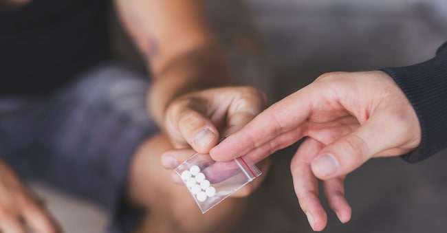 Drug dealer selling ecstasy pills to a drug addict Impact Photography - stock.adobe.com