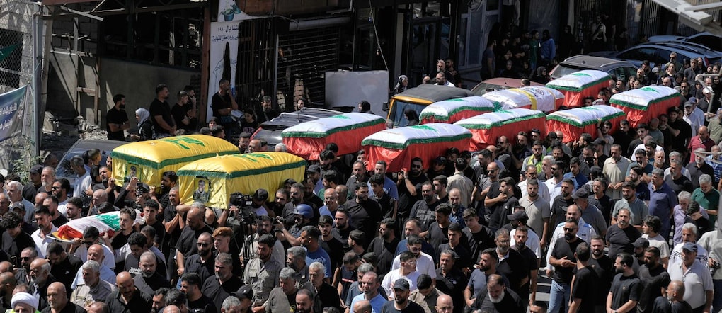 Una folla di persone trasporta le bare delle vittime di un attacco aereo israeliano avvenuto lunedì nel Libano meridionale APN