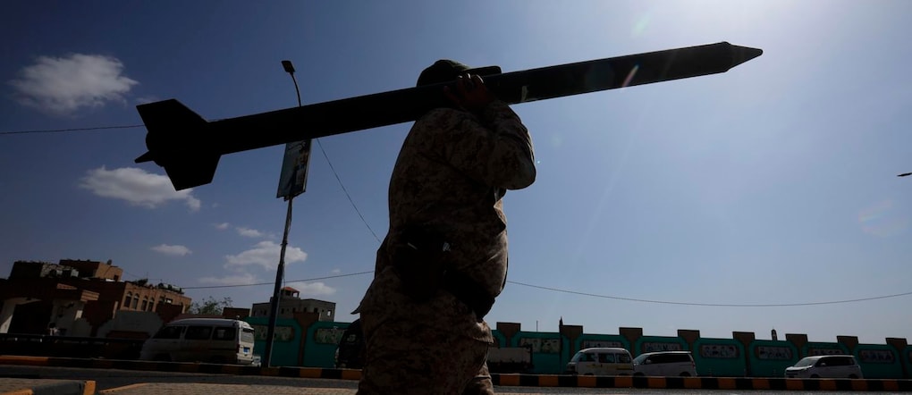 Un combattente Houthi trasporta un finto missile mentre marcia durante una campagna di mobilitazione per arruolare altri combattenti di fronte all’escalation dei combattimenti, a Sana’a, Yemen EPA