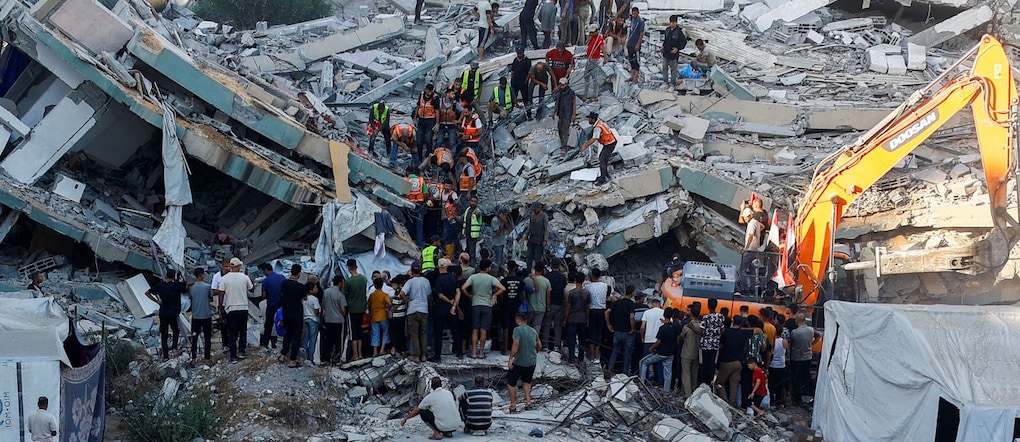 La gente si raduna mentre gli operatori della Protezione Civile cercano di soccorrere le persone rimaste intrappolate sotto le macerie di un edificio residenziale che era stato danneggiato in un precedente attacco israeliano durante la guerra e che è crollato mercoledì, nella città di Gaza, il 16 settembre 2026. REUTERS/Mahmoud Issa REUTERS