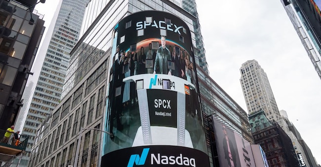 Il discorso di Elon Mask prima dell’inizio della cerimonia di apertura del NASDAQ proiettato su uno schermo all’esterno dello Stock Exchange a Times Square il 12 giugno 2026 a New York . (Reuters)
