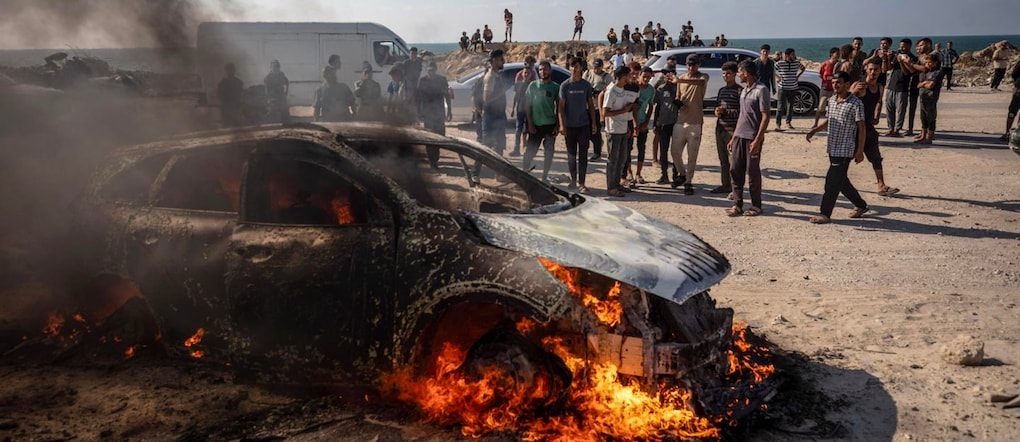 Alcuni palestinesi si radunano vicino a un veicolo in fiamme dopo che è stato colpito da un attacco aereo israeliano a sud della città di Gaza, nella Striscia di Gaza, il 24 settembre 2026. Secondo il Ministero della Salute palestinese di Gaza, almeno una persona è rimasta uccisa e altre tre sono rimaste ferite quando l’auto è stata colpita.  EPA/MOHAMMED SABER EPA