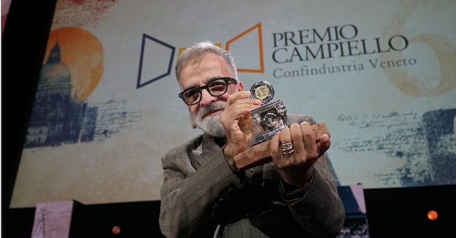 Lo scrittore Marcello Fois, vincitore della 64° edizione del Premio Letterario Campiello con “L’Immensa distrazione” (Einaudi)  posa sul palco reggendo con le mani l’ambito premio, al termine della cerimonia finale, nella sala grande del Palazzo del Cinema del Lido, Venezia 3 ottobre 2026. ANSA/ANDREA MEROLA ANSA